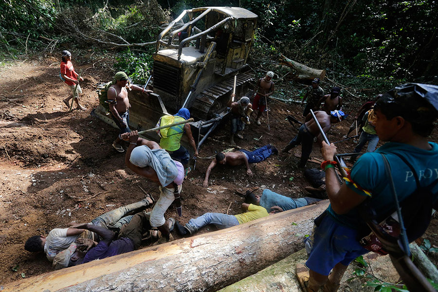 Ka’apor savaşçıları ormancılara vurmak için sopa kullanıyor (Fotoğraf: Lunae Parracho/Reuters)