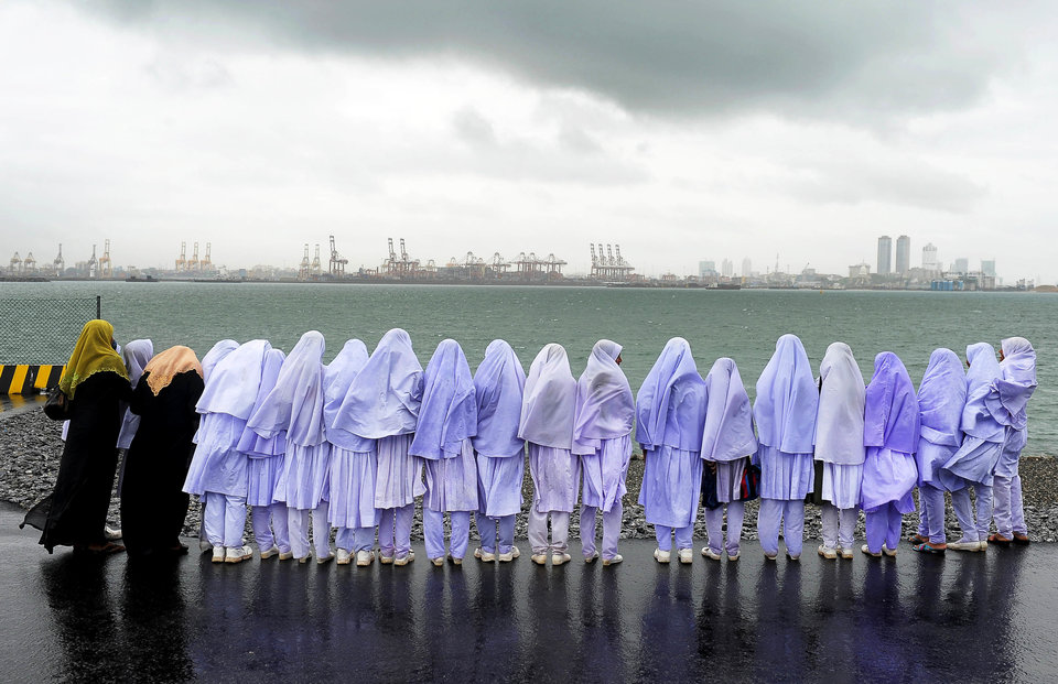 Sri Lankan Muslim school girls stand on the edge of a sea port in Colombo on May 20, 2013, after travelling from their town of Kalmunai, over 370 kilometres (231 miles) east of the capital Colombo. Work on a USD 500-million new container terminal is nearing completion at Colombo which is a key transhipment hub for Indian cargo. AFP PHOTO/ LAKRUWAN WANNIARACHCHI (Photo credit should read LAKRUWAN WANNIARACHCHI/AFP/Getty Images)