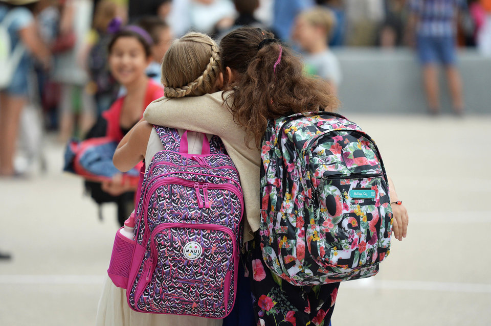 Girls hug each other outside the European school of Strasbourg (Ecole Europeenne de Strasbourg) in Strasbourg, eastern France, on September 1, 2015, the first day of the new school year. AFP PHOTO / PATRICK HERTZOG (Photo credit should read PATRICK HERTZOG/AFP/Getty Images)