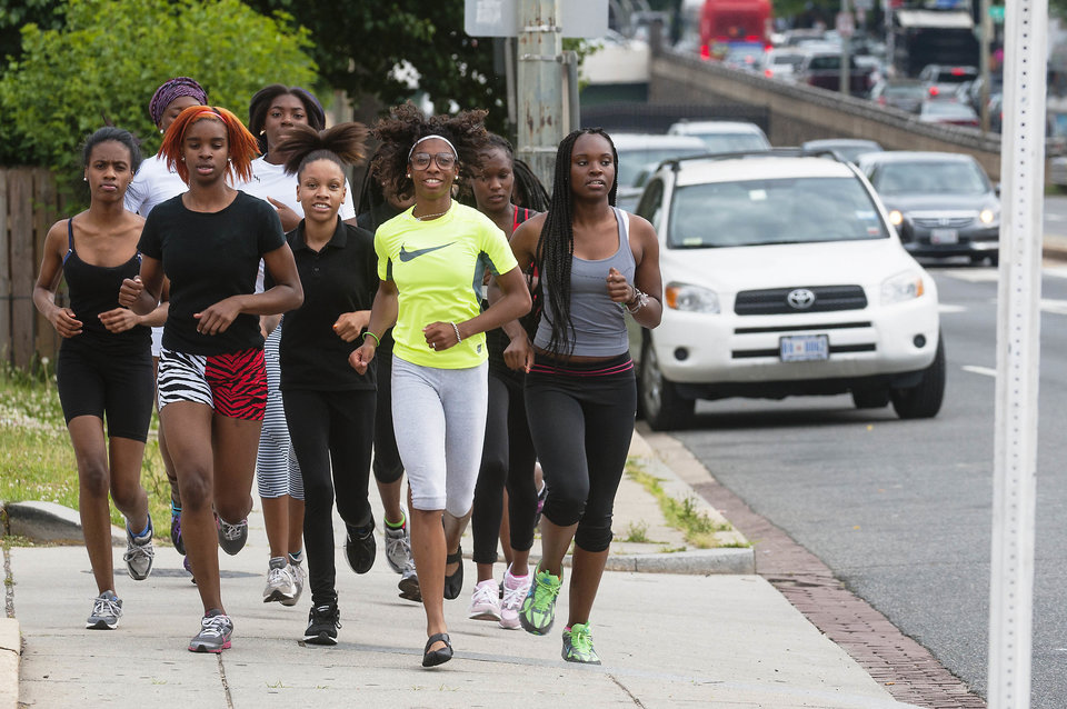 WASHINGTON, DC - MAY 28: The Dunbar girls' track team runs from their school through traffic as they travel up N. Capitol Street to McKinley High School where they practice Tuesday May 28, 2013 in Washington, DC. Despite not having a track of their own, the girls excel. (Photo by Katherine Frey/The Washington Post)